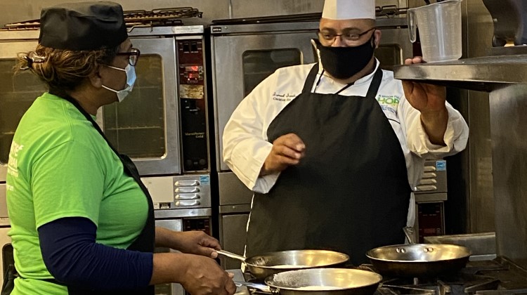 Chef Instructor provides hands-on lesson to student in the kitchen. 