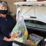 Woman loads fresh produce into the trunk of a car at St. Cloud Community Pantry.