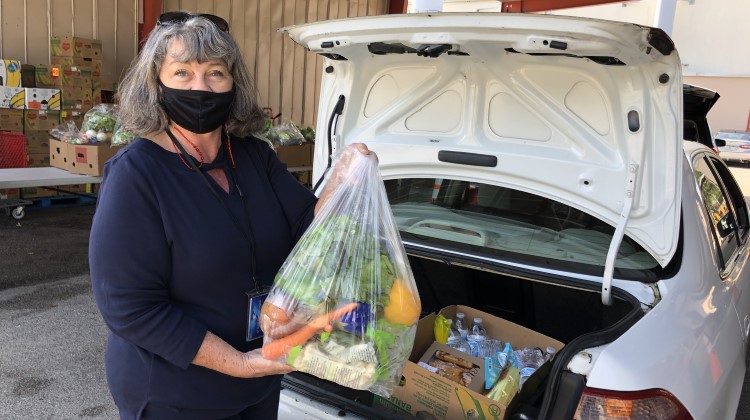 Woman loads fresh produce into the trunk of a car at St. Cloud Community Pantry.